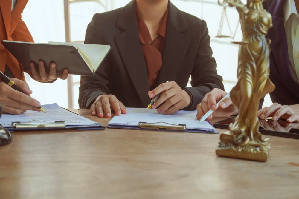 A group of lawyers and clients engage in a professional meeting at a law office, discussing agreements, contracts.